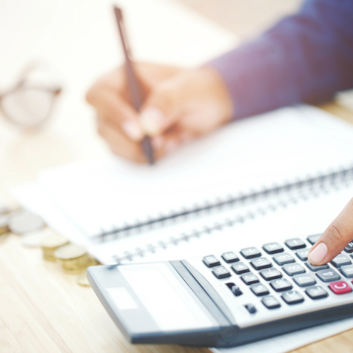 woman working at desk with calculator and pen and paper